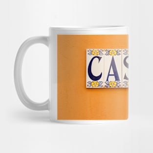 Village street in old Spanish town with Spanish word CASA in tiles on orange wall Mug